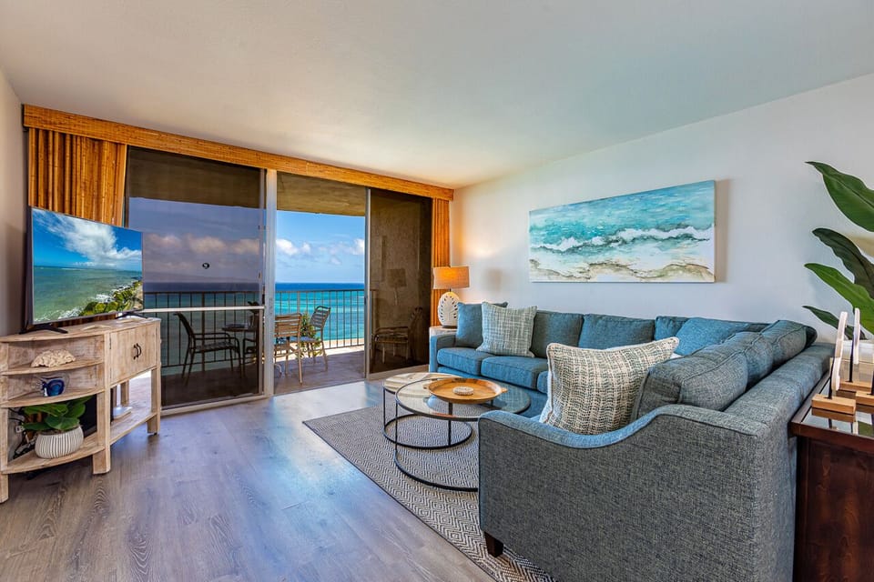 Sink into the plush sectional and let the ocean breeze drift in through your private balcony. Your coastal retreat awaits with stunning sea views and calming artwork that echoes the waves beyond.