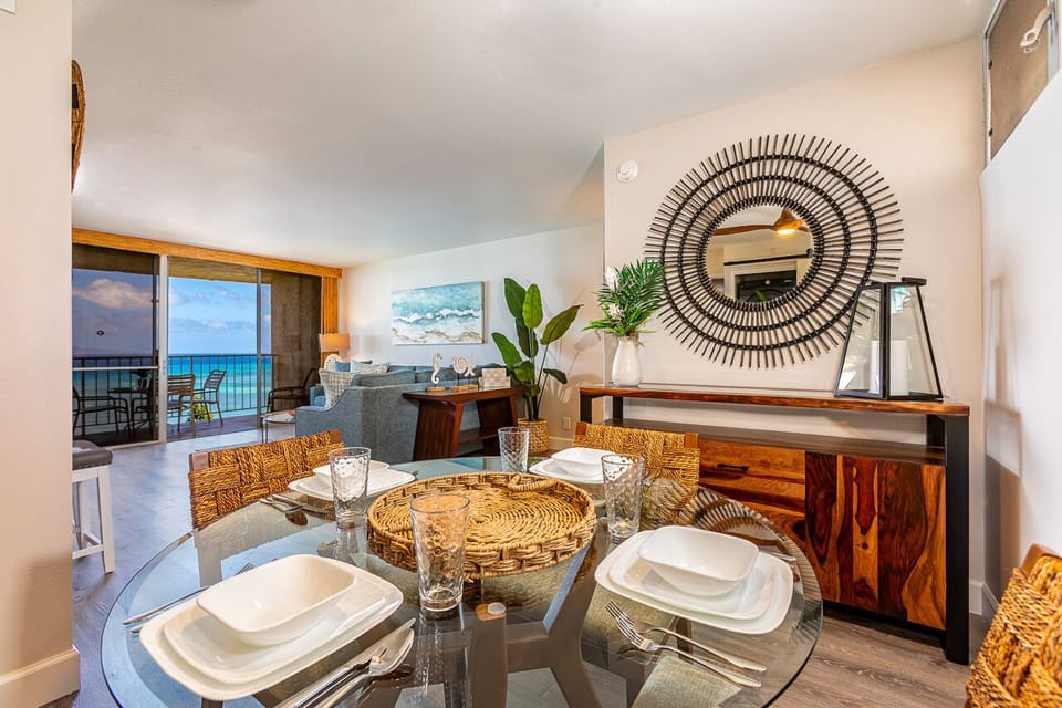 Gather with loved ones around the elegant glass dining table, where ocean breezes and turquoise views through the balcony doors create the perfect backdrop for memorable meals together.