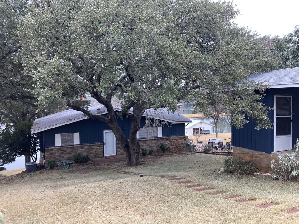 Street view, glimpse of the carport. View from parking space for 2-3 cars.  