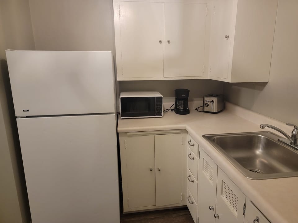 Kitchen w/essentials, microwave, stove, oven, refrigerator, freezer, coffee machine