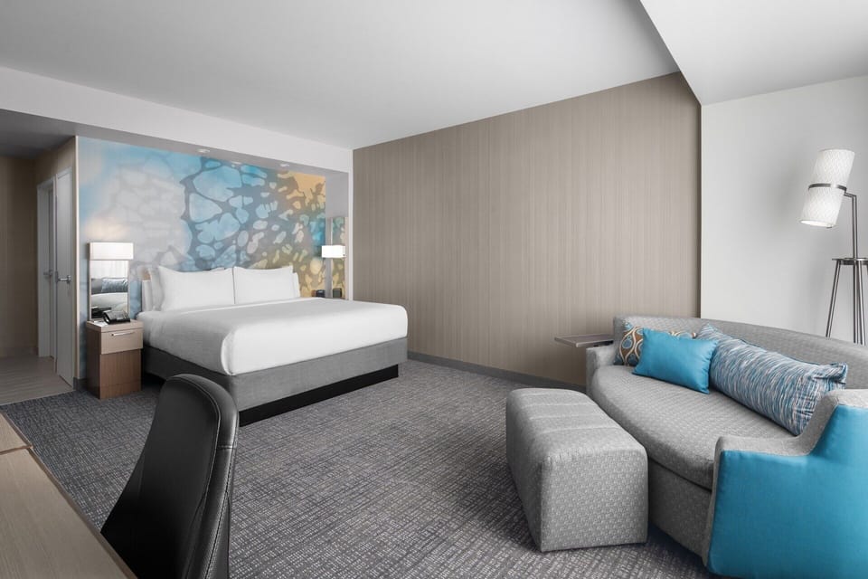 Unwind in a spacious room with plush bed and cozy sofa