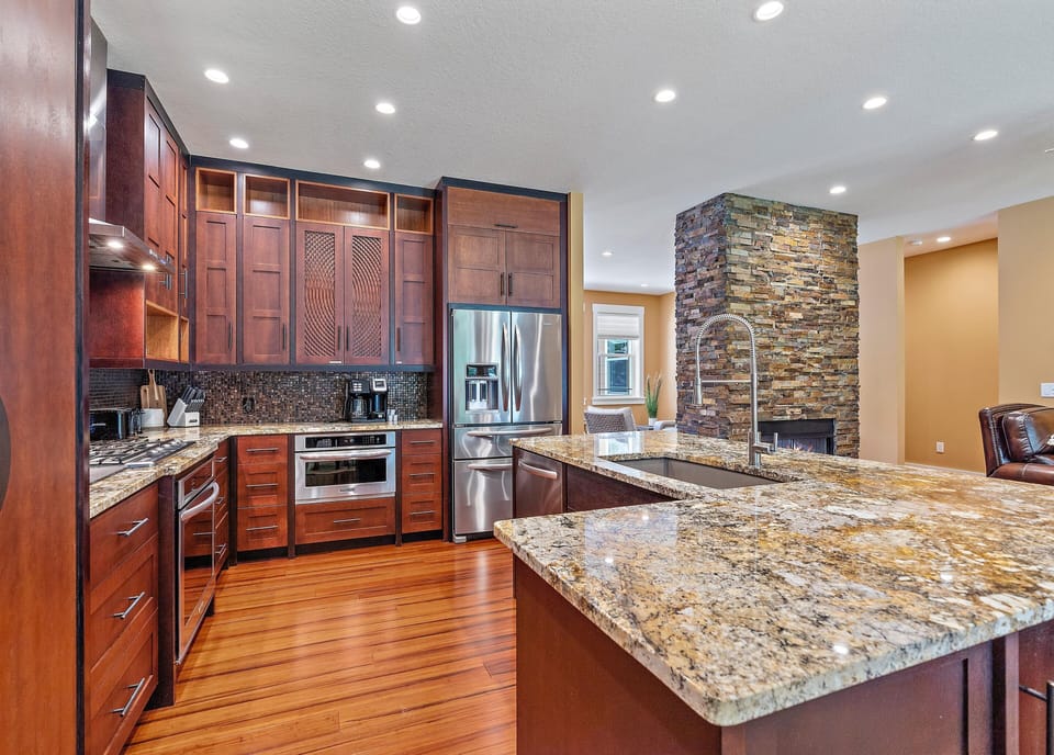 Grand kitchen with floor to ceiling windows and spotless appliances.