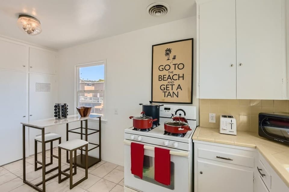 Enjoy the full kitchen with a seating area, a refrigerator, oven, stove, microwave, coffee, creamers, mixers, spices, pots, pans, cooking supplies, cutlery, cups, plates, bowls, utensils, small appliances, and many more essentials.