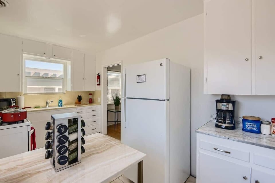 Enjoy the full kitchen with a seating area, a refrigerator, oven, stove, microwave, coffee, creamers, mixers, spices, pots, pans, cooking supplies, cutlery, cups, plates, bowls, utensils, small appliances, and many more essentials.
