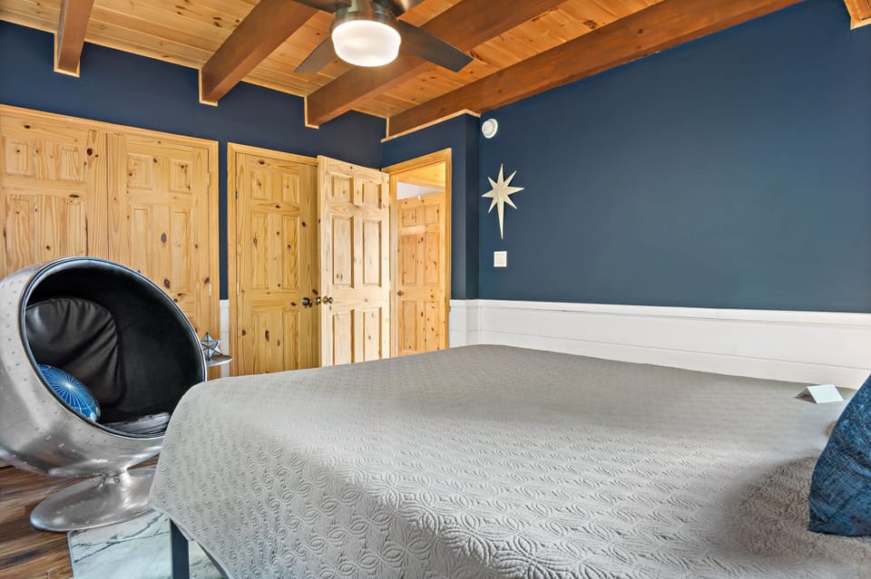 Main floor bedroom with Queen bed & far-out chair for seating.