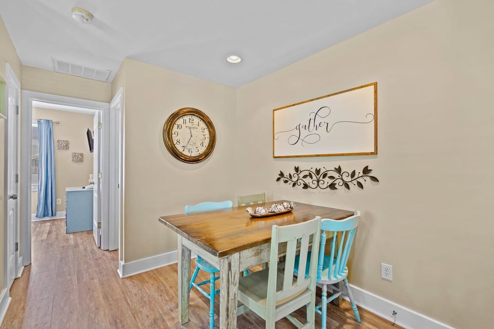 Gather around your charming dining nook with rustic wooden table and cheerful blue chairs, perfect for morning coffee or intimate meals.