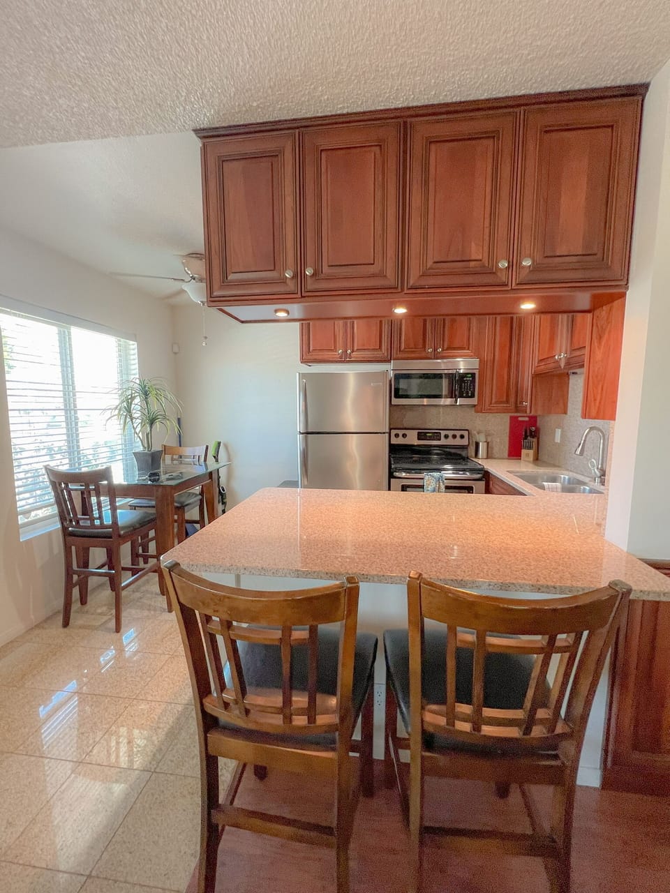kitchen view, bar stools, small dining area to the left