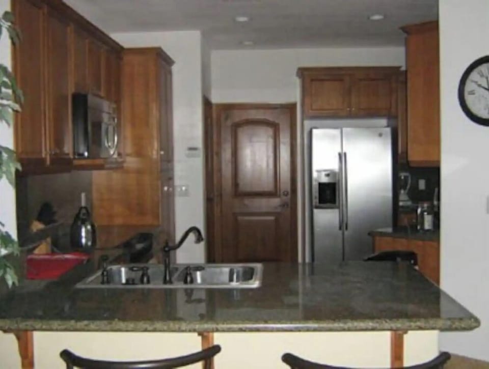 Fully equipped kitchen with 3 counter-height stools on the peninsula