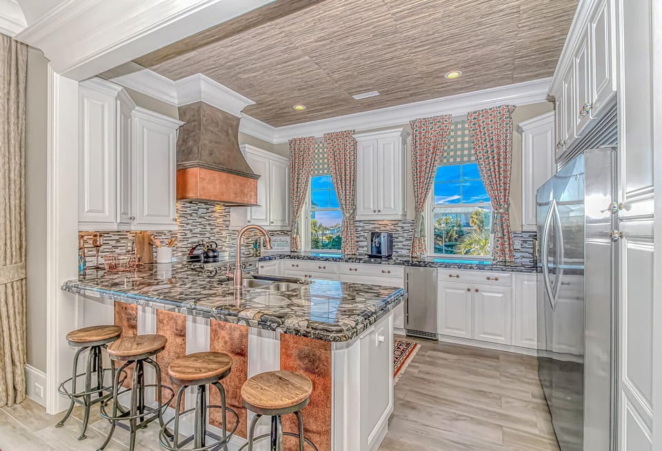 Your gourmet kitchen awaits with granite countertops, stainless appliances, and a breakfast bar perfect for morning coffee with poolside views.