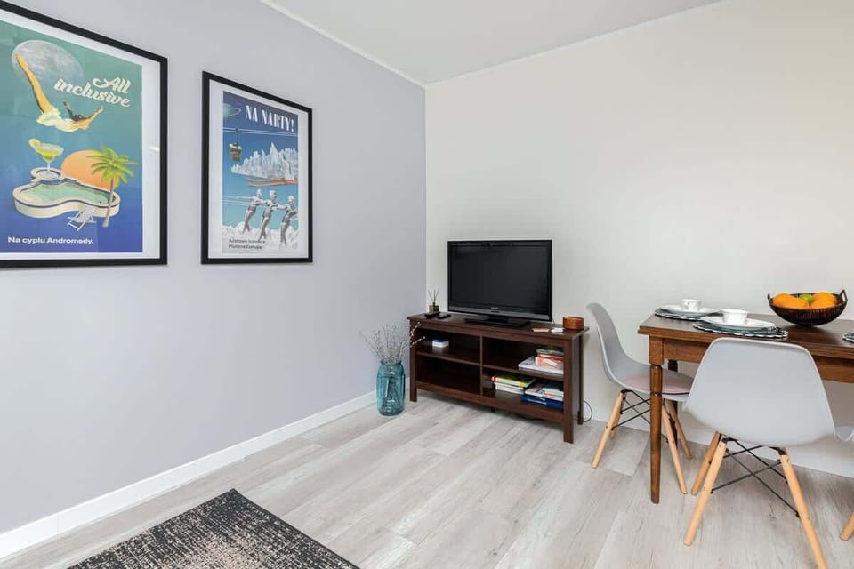  Another view of the living room with a gray sofa, decorative cushions, artwork on the wall, and a soft, textured rug.