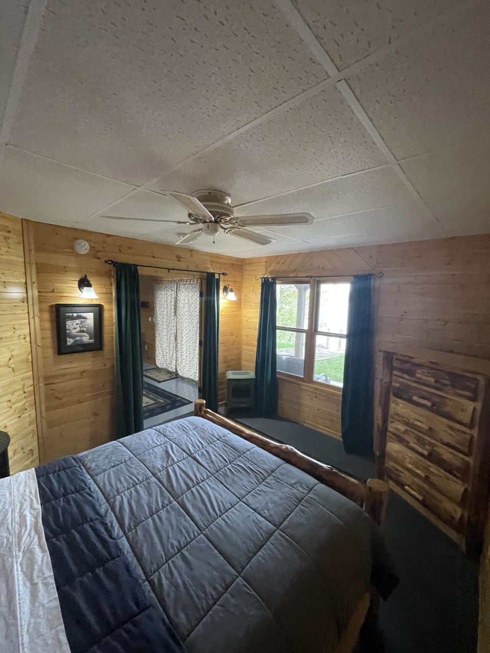Lower bedroom with a queen bed and electric fireplace. 