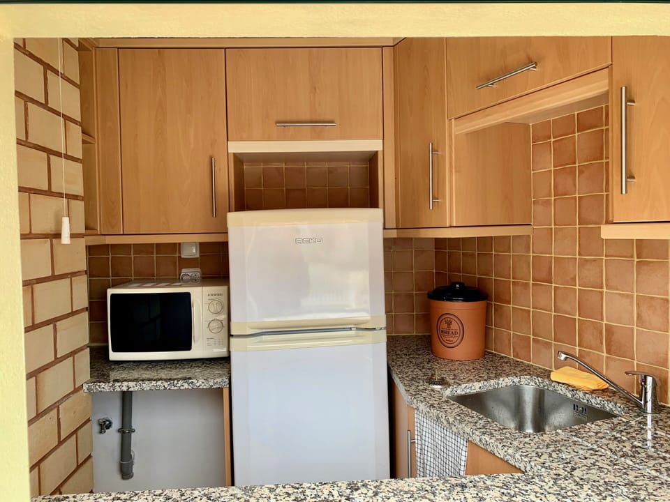 Pool kitchen with fridge and microwave, pass through to pool area
