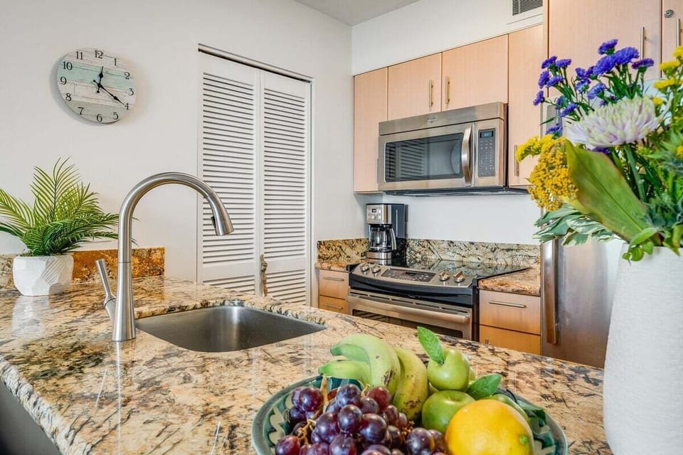 A stylish kitchen featuring polished granite countertops, stainless steel appliances, and warm wood cabinetry