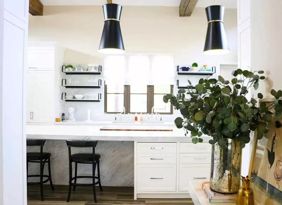 A stylish overhead chandelier completes the elegant look of the space in kitchen