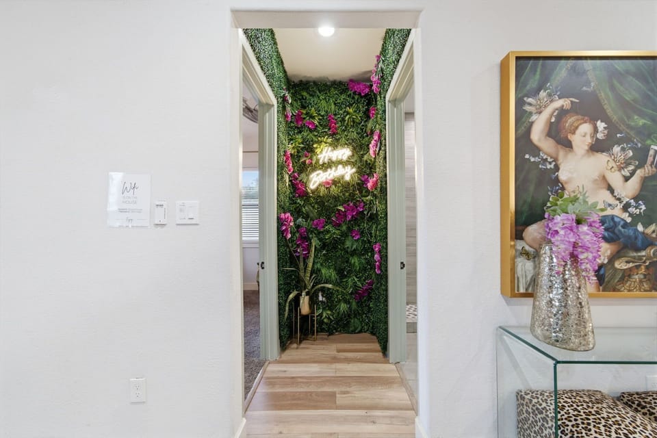 Chic hallway with floral greenery wall and glowing neon accent