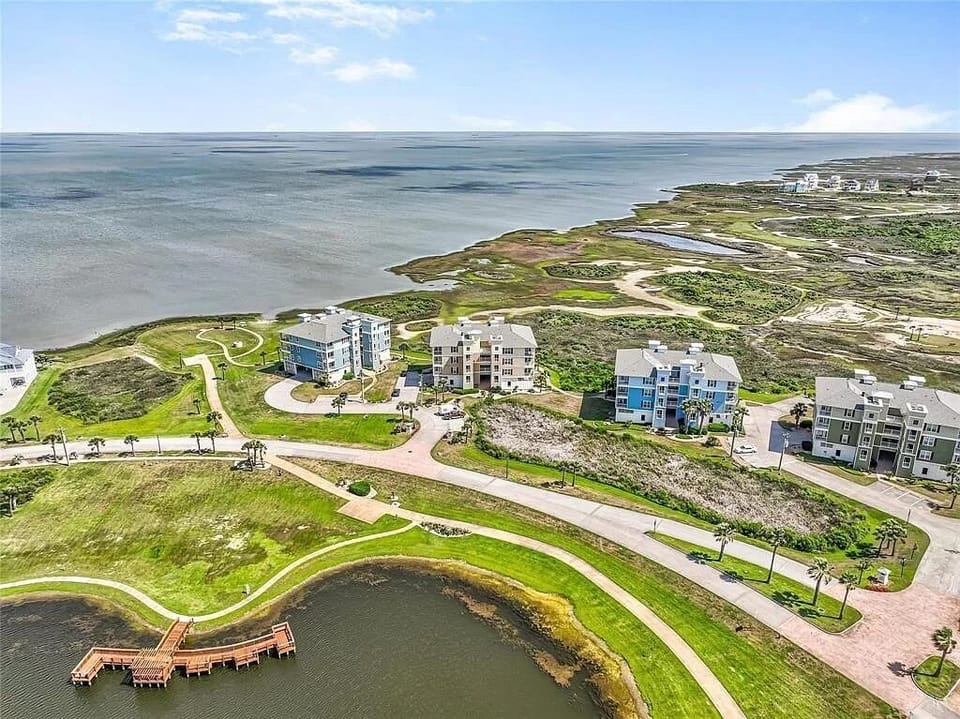 Looking east yellow water front building with fishing pond in front.