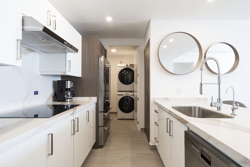 The complete kitchen and a view of the washer and dryer.