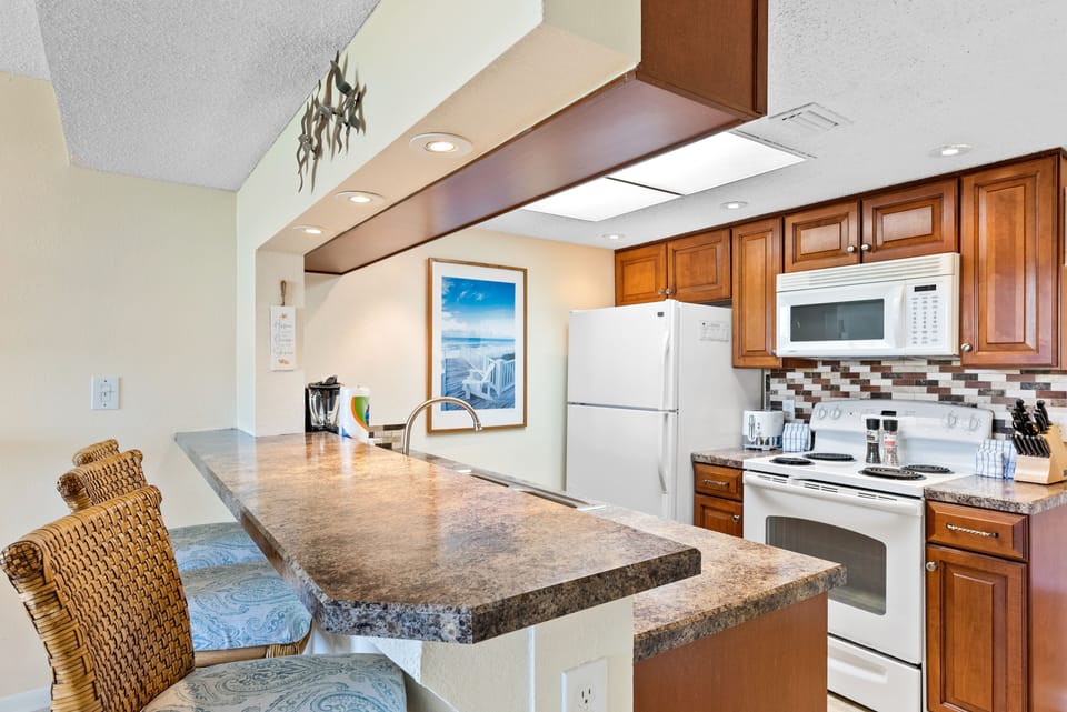 Open-concept kitchen with a breakfast bar and wooden cabinets.