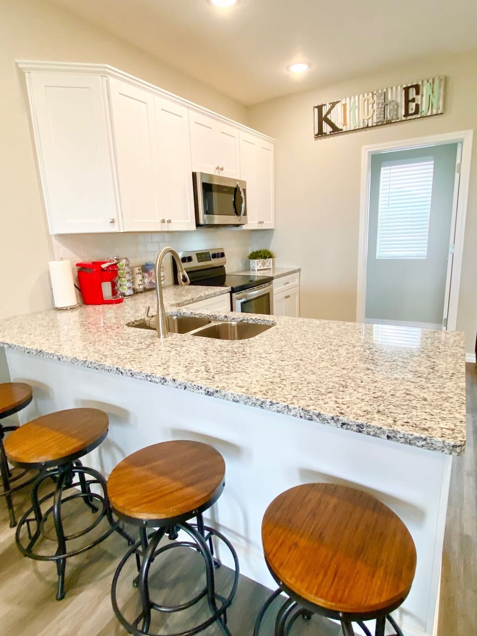 Open kitchen with additional seating at kitchen counter and bar