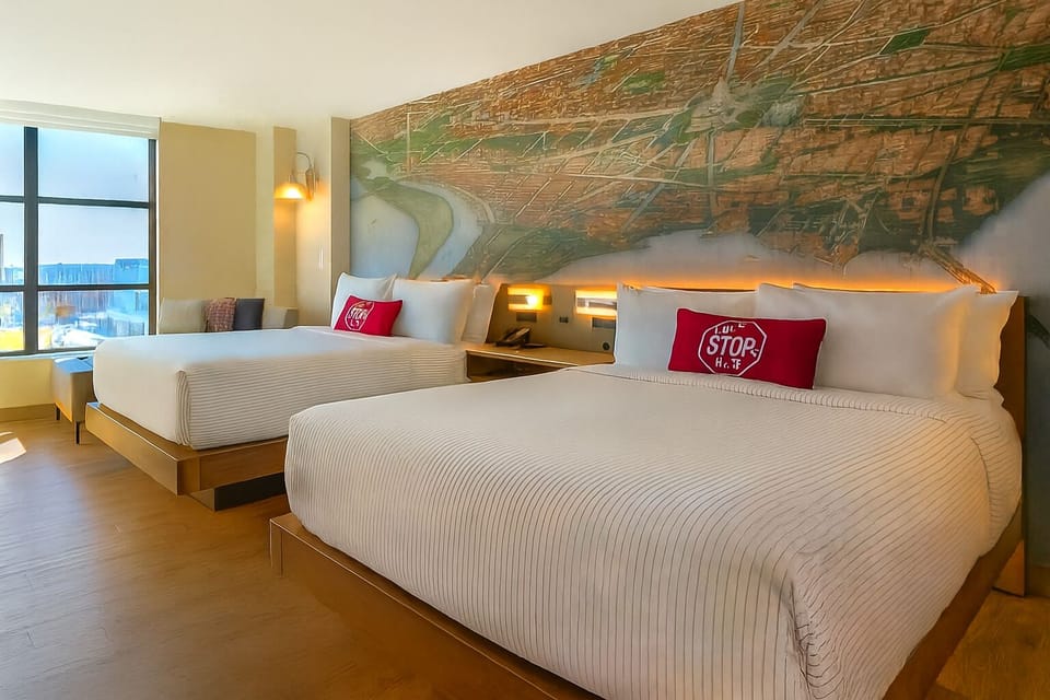 Unwind in crisp linens with skyline views and warm lighting.