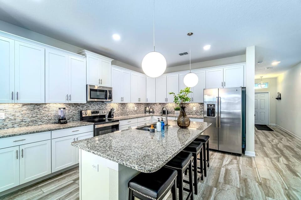 Beautiful high-end kitchen for the family to gather around. Stainless steel appliances and island/bar.