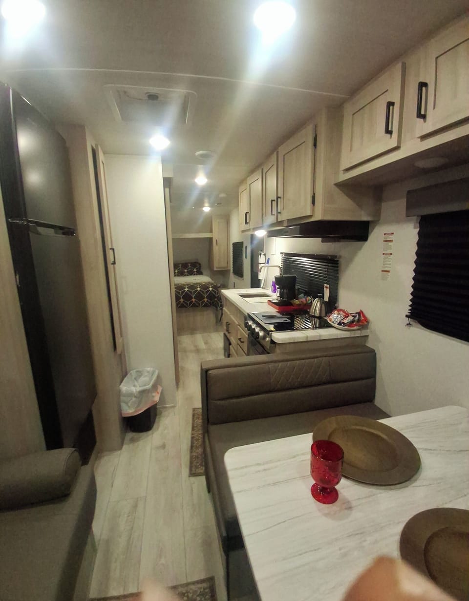 

couch,stovetop, refrigerator,  coffee maker, microwave living area, kitchen