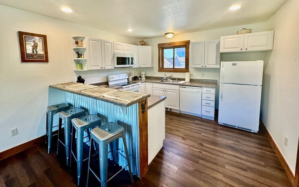 a fully equipped kitchen with a breakfast bar for casual dining or morning coffee.
