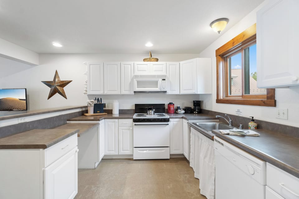 A fully equipped kitchen with a breakfast bar for casual dining or morning coffee.
