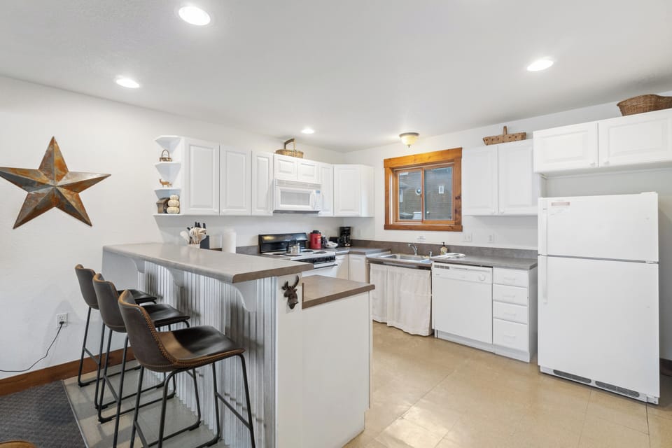 A fully equipped kitchen with a breakfast bar for casual dining or morning coffee.
