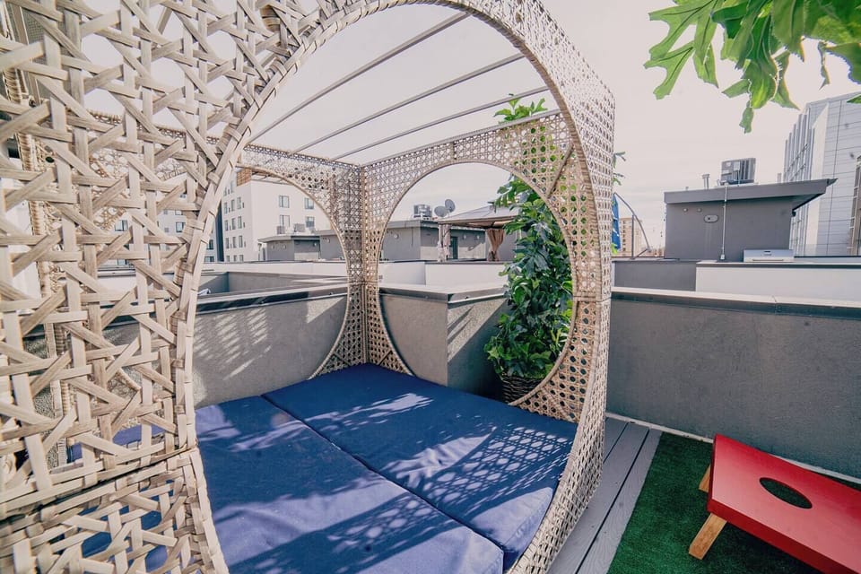 Chic rooftop balcony featuring a cozy cabana, perfect for relaxation with city views. Enjoy sunny days or starry nights in comfort and style.