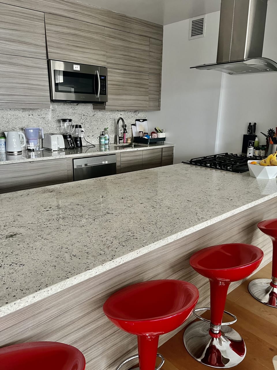 Kitchen has an island and bar stools
 