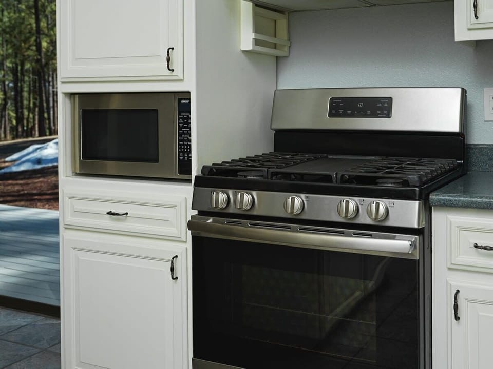 The kitchen is equipped with a large gas range and microwave. Whether you're simmering a savory sauce or quickly heating up leftovers, the combination of these top-notch appliances ensures that your cooking experience is efficient and enjoyable.