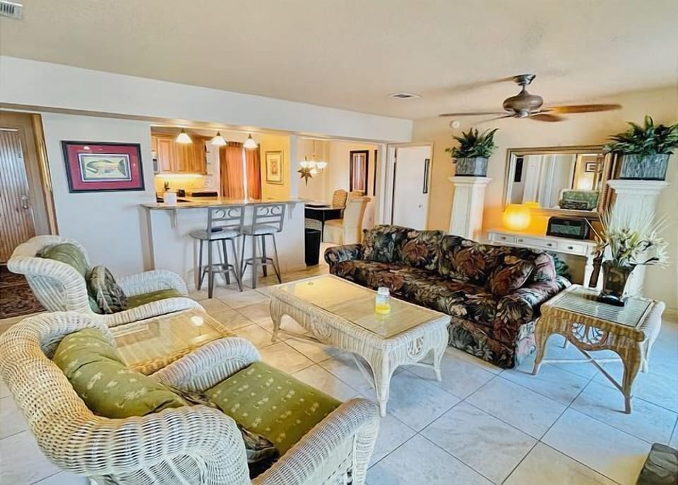 Unwind in your spacious living room with comfortable wicker furniture and tropical touches that create the perfect beach retreat atmosphere.