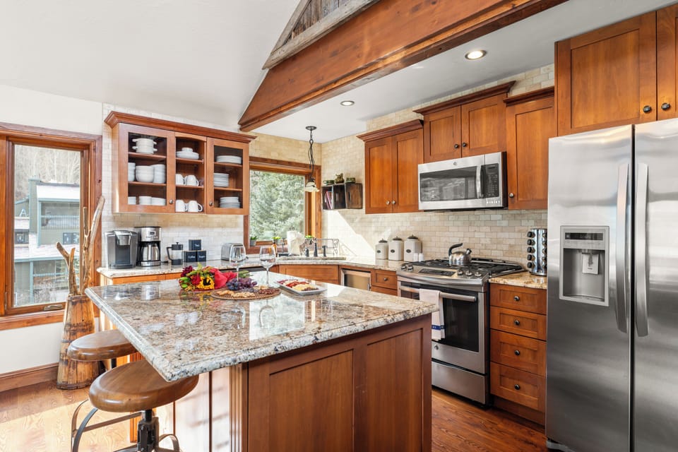 Kitchen with barstool seating and modern appliances.
