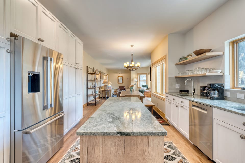 Modern kitchen with sleek countertop and large refrigerator.
