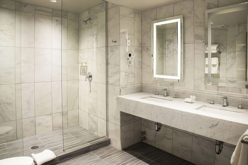 Refresh in a sleek marble bath with walk-in shower.