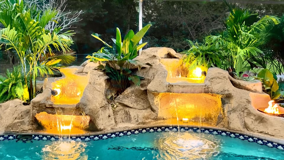 Lighted waterfall with fire feature gives a tropical oasis vibe!