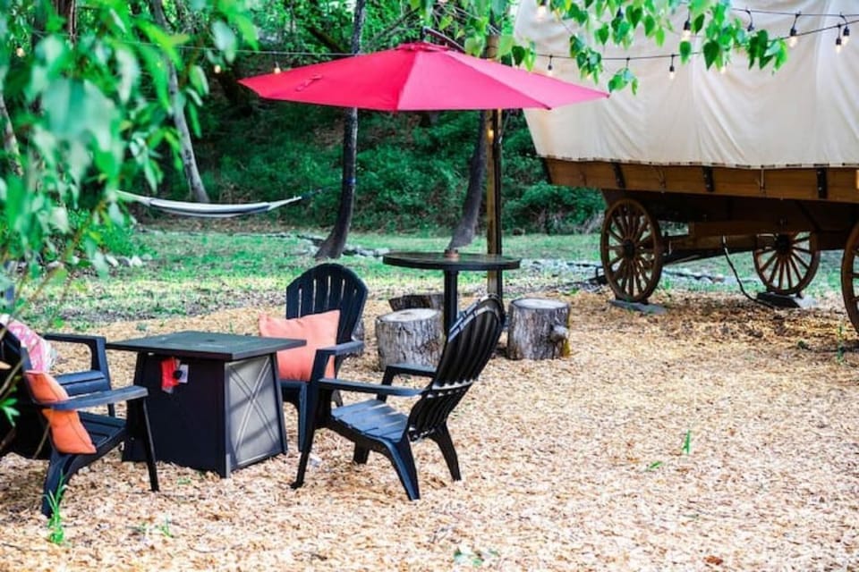 Outdoor patio area w/ firepit, table, BBQ, hammock & large umbrella.