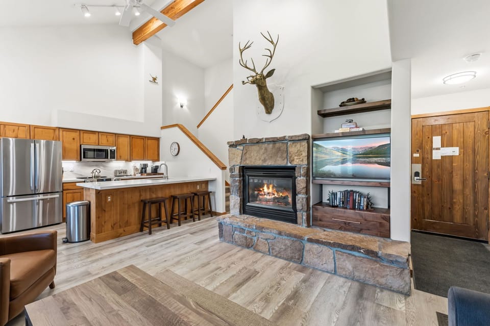 Unwind in your open-concept retreat with soaring ceilings, a cozy stone fireplace, and a fully-equipped kitchen—your perfect mountain getaway.