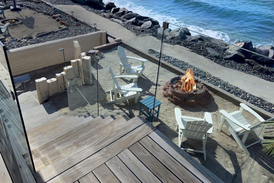 Downstairs patio  leads to private fire pit area, beach shower and storage area with extra chairs and beach toys and umbrella.