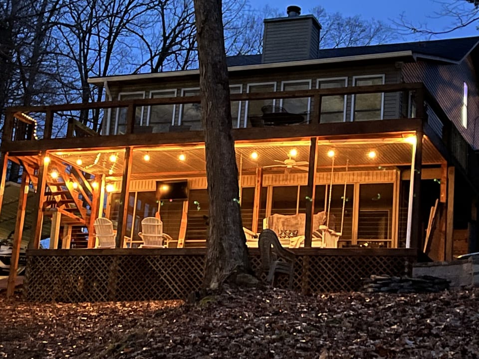 Back deck of house. Daybedswing, bar area with TV and large porch swing bed.