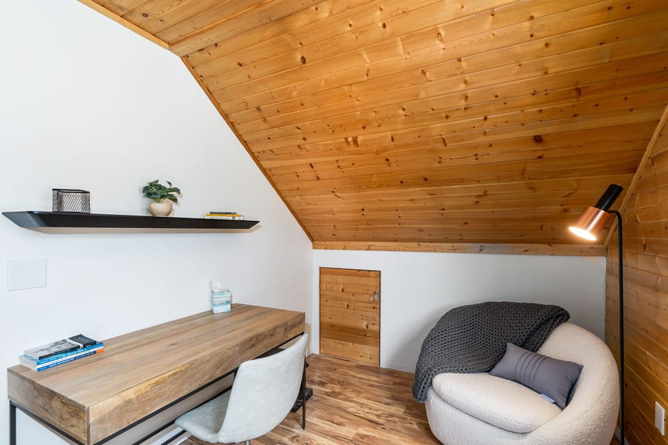 Upstairs bedroom office space with a desk, chair and printer.