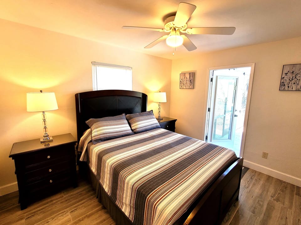 2nd bedroom with queen size bed and door to patio.