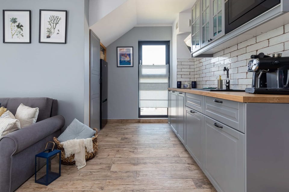 A living space featuring a comfortable sofa, stylish coffee table, and a door leading to the kitchen area.