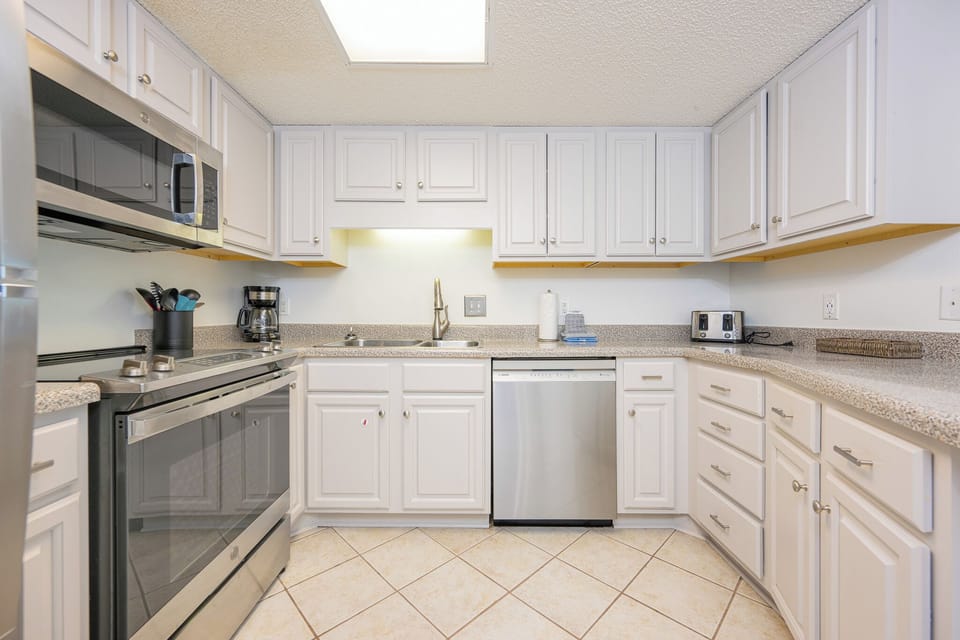 Prepare meals in this modern kitchen featuring stainless appliances, ample counter space, and stylish cabinetry