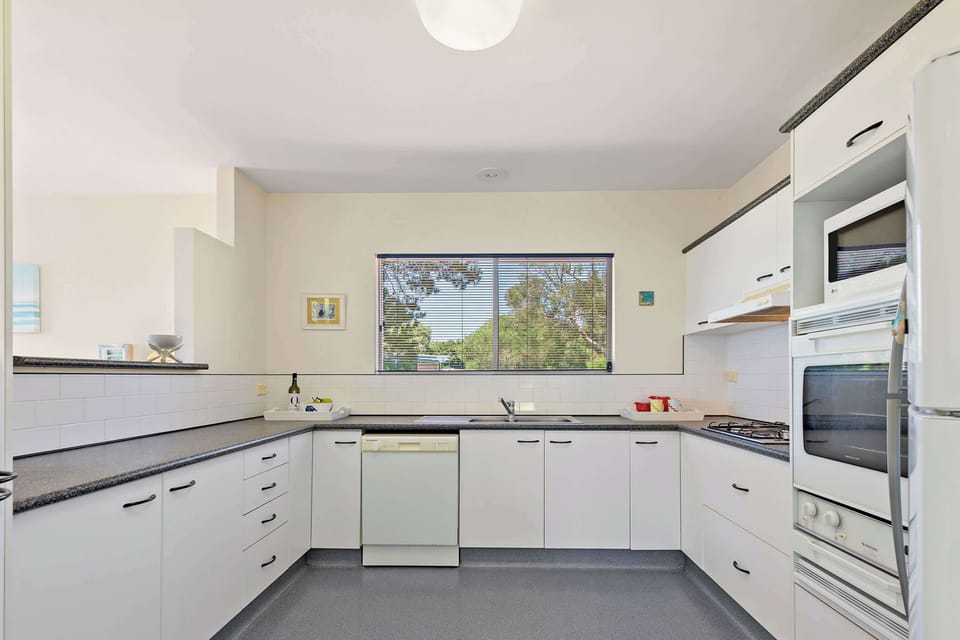 Fully equipped kitchen with electric oven, gas cooktop & dishwasher.