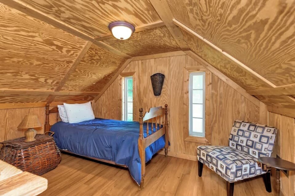 Upstairs twin size bed on one side of the open loft area.