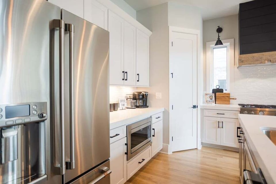 Kitchen with Coffee Bar - Unleash your inner chef in the gourmet kitchen at The Savant Nashville. Featuring a custom range hood and gas stove, it's the perfect setting to cook up culinary delights. Your luxury escape awaits! 