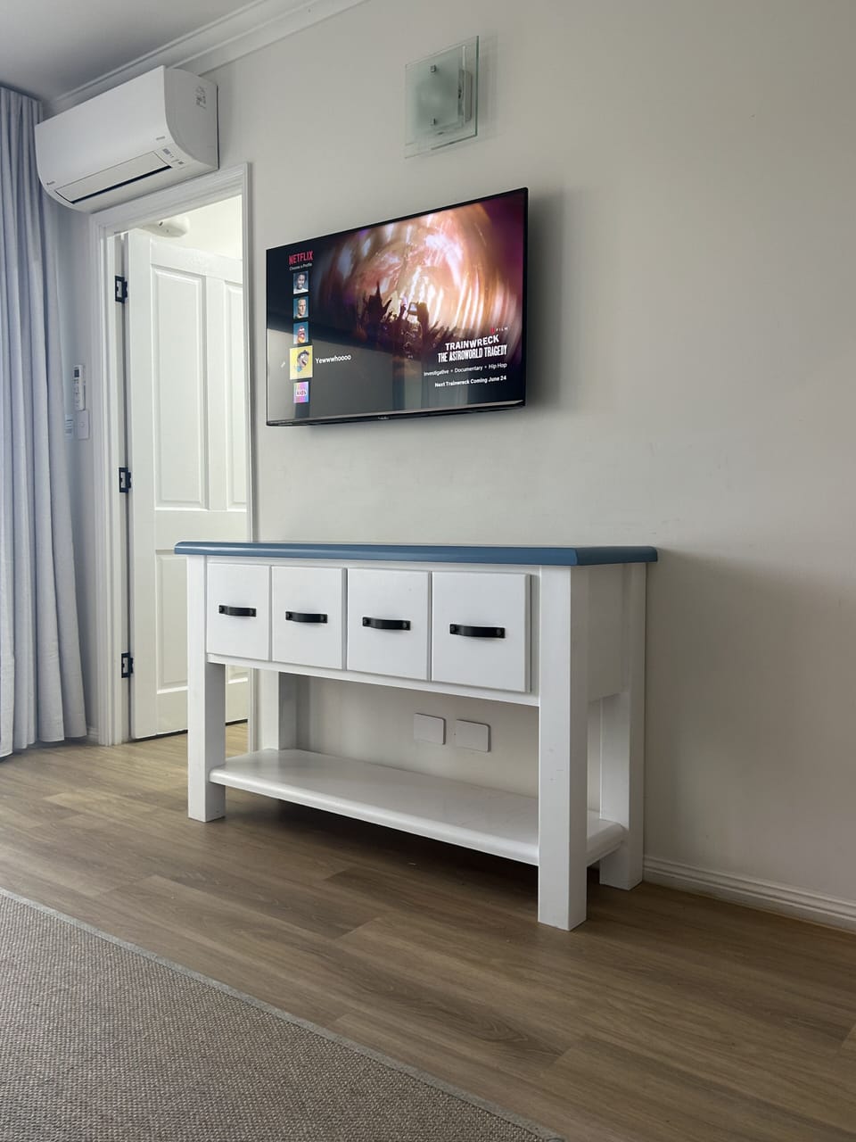 Master bedroom with wall-mounted TV and storage unit