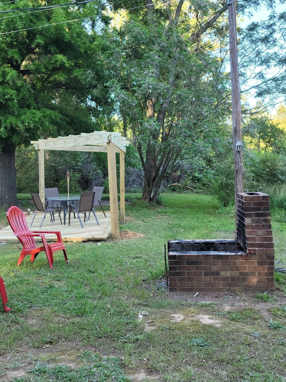 Relax by the firepit after an enjoyable dinner under the trellis.